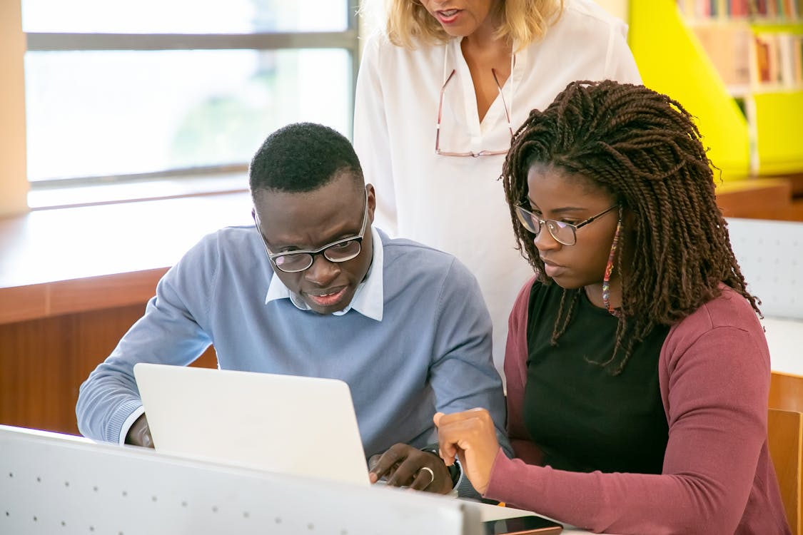 Young Black students working collaboratively on a laptop